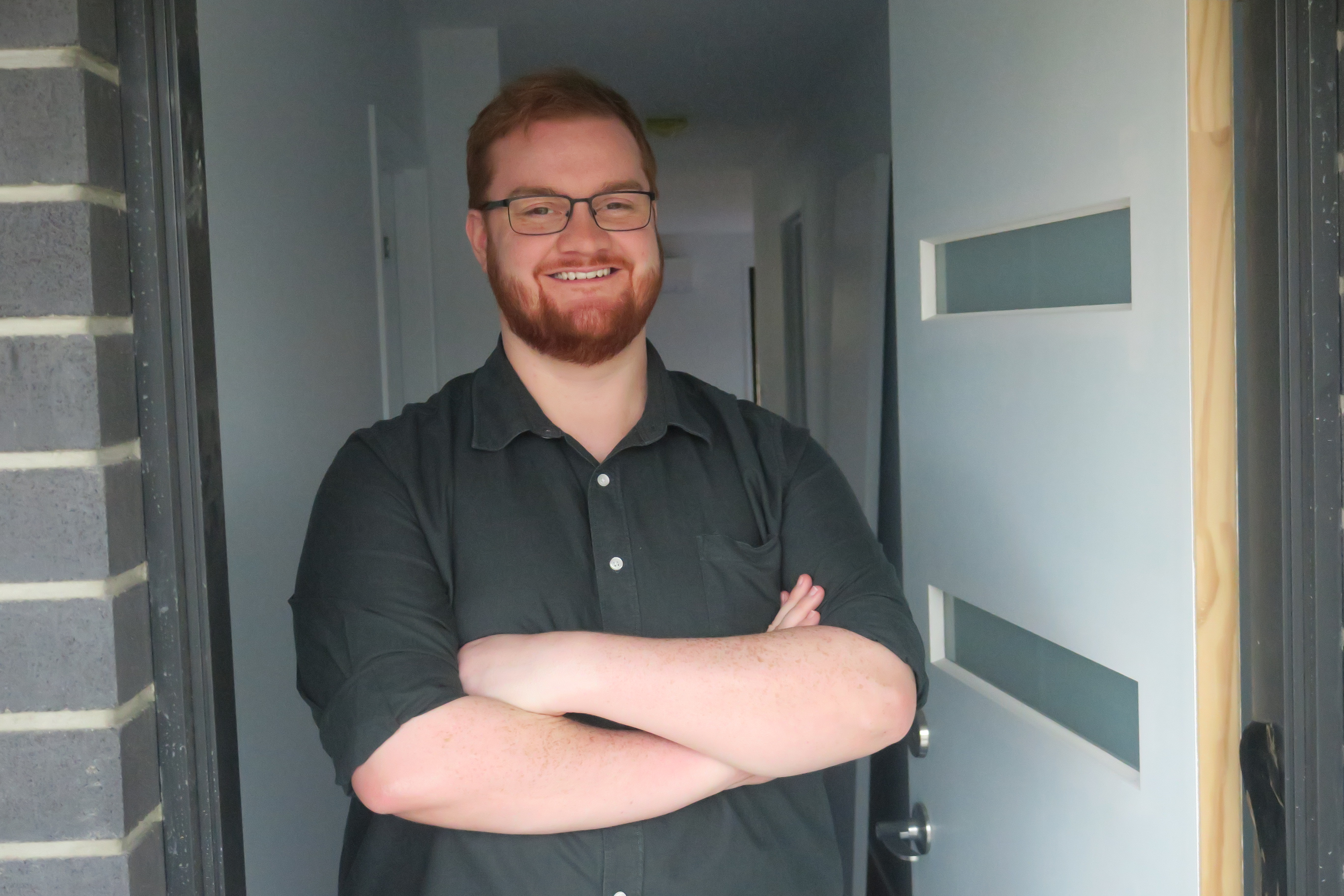 Josh Reeve standing in the doorway of his new home.