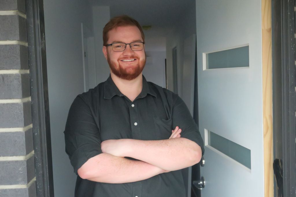 Josh Reeve standing in the doorway of his new home.